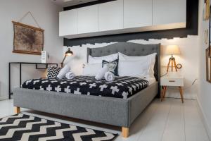 um quarto com uma cama com um edredão preto e branco em Belváros Apartman em Veszprém