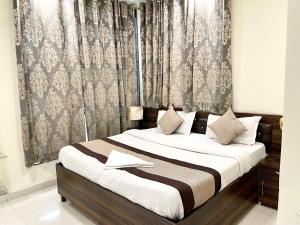 um quarto com uma cama grande e uma cortina em The Grand Suite-70 em Noida