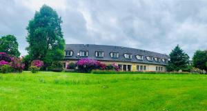a large house with a green field in front of it at Penzion G in Šumperk