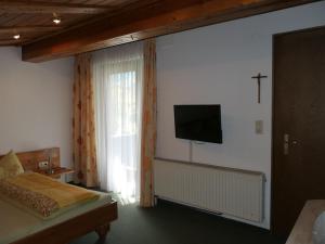 ein Schlafzimmer mit einem Bett und einem TV an der Wand in der Unterkunft Fewo Schrottenbaum in Bürs