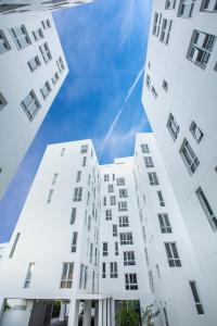 two tall white buildings looking up into the sky at Karin hotel & Service apartment - SHA Extra Plus in Si Racha