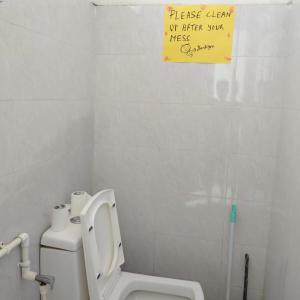 a bathroom with a toilet and a sign on the wall at Traveler House in Dimāpur +32 photos