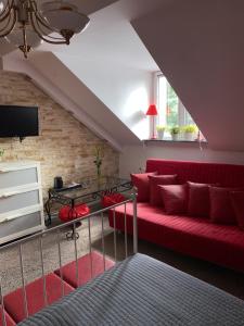 ein Wohnzimmer mit einem roten Sofa und einem TV in der Unterkunft Noclegi pod Słonecznikiem in Gąsawa