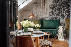 a living room with a green couch and a table at Belváros Apartman in Veszprém