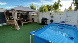 un patio trasero con piscina y sombrilla en Lilo 30, Only Families, Puy du Fou, en Olías del Rey