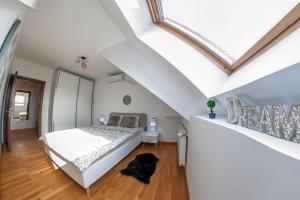 a white bedroom with a bed and a staircase at Old Town Bohemian Attic in Bucharest