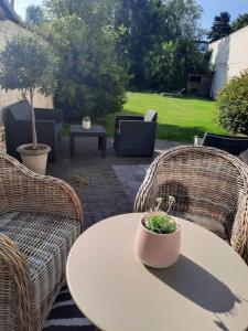 un patio con sillas de mimbre y una mesa con una planta. en Dolce far niente, en Brujas