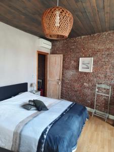 a bedroom with a large bed and a brick wall at Dolce far niente in Bruges