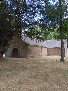 Sainte-Marie的住宿－chez christine，一座旧砖砌的建筑,有一扇门和一棵树