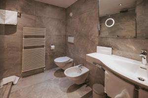 a bathroom with a toilet and a sink and a toilet at MANNI das Hotel in Mayrhofen