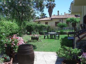 einen Garten mit Tisch und Stühlen und ein Haus in der Unterkunft Sybaris B&B in Marina di Sibari