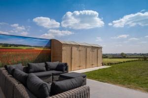 a large wall mural of a field with a couch at Akkerland - Luxe vakantiehuisje met Infra-Rood sauna - 2 à 6 pers in Zonnebeke