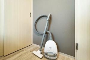 a vacuum cleaner in a room next to a door at Lafesta Higashikomagata in Tokyo