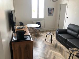 a living room with a couch and a table at Superbe appartement indépendant en centre ville in Vichy