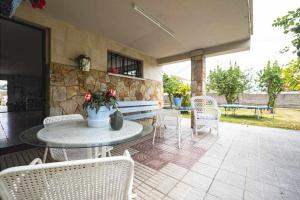 a patio with a table and chairs and a stone wall at La Huertina De Granda in Candanal
