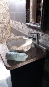 a bathroom counter with a sink and a mirror at Dar Ghita en campagne in O Ben Slimane