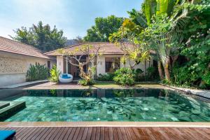 a swimming pool in front of a house at The Akasha Luxury Villas in Seminyak