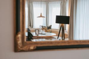 a reflection of a living room in a mirror at MANNI das Hotel in Mayrhofen