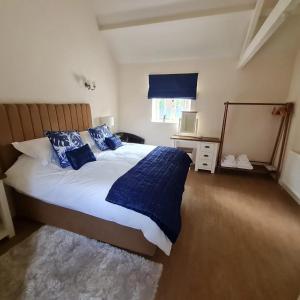 a bedroom with a bed with blue pillows and a mirror at Kings Head in North Lopham