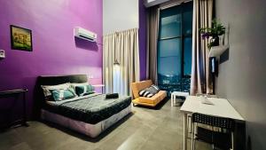 sypialnia z fioletowymi ścianami, łóżkiem i krzesłem w obiekcie Montana Suites, Empire Damansara w mieście Petaling Jaya