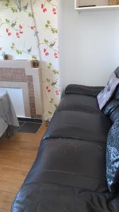 a black bed in a room with a wall at Home from Home in London