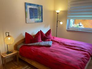 a red bed in a bedroom with a window at Wellenwiese 29 in Zingst