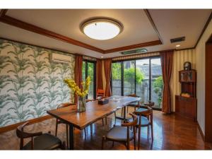 - une salle à manger avec une table et des chaises en bois dans l'établissement Shirakabanoyado Izumi - Vacation STAY 95387v, à Izumi-Sano