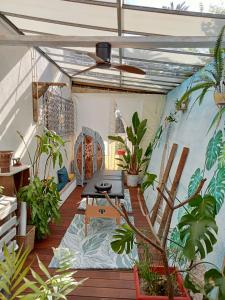 balcón con plantas, mesa y techo en logement atypique avec jacuzzi et piscine, en Carnoules