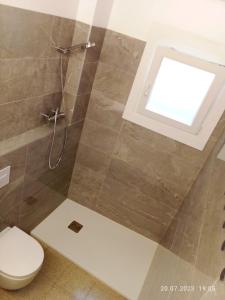 ein Bad mit Dusche, WC und Fenster in der Unterkunft Newly renovated 2 bed apartment in Blanes old town 50m from the beach! in Blanes