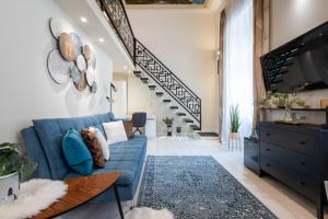 ブダペストにあるSzent István Apartmentsの青いソファと階段のあるリビングルーム