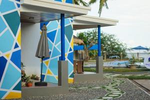 a colorful building with an umbrella and a pool at B Ternate Resort in Dauin