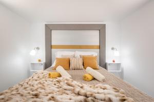 Szent István Apartments في بودابست: غرفة نوم بسرير كبير مع مخدات صفراء