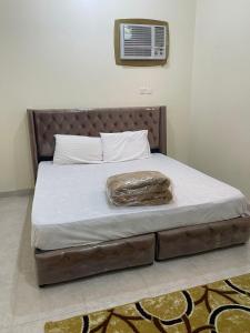 a bed in a bedroom with a blanket on it at شقق بن طالب in Khamis Mushayt