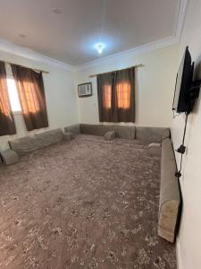 a living room with a couch and a flat screen tv at شقق بن طالب in Khamis Mushayt