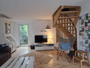 ein Wohnzimmer mit Treppe und Fernseher in der Unterkunft Wellenbude in Otterndorf