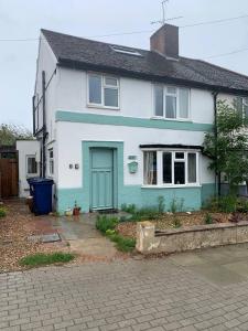 une maison blanche et bleue avec une porte bleue dans l'établissement Spring, à Whetstone