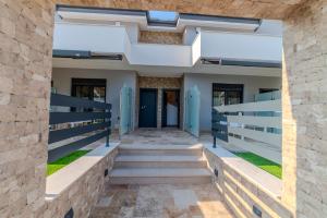 Dream Luxury Apartments في ستافروس: اطلالة خارجية على مبنى بأبواب زرقاء ودرج