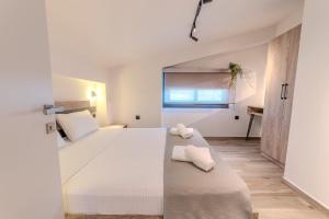 a bedroom with a large white bed with towels on it at Dream Luxury Apartments in Stavros