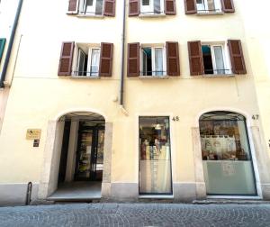 a building with three doors and windows on a street at B&B Nonna Costantina in Chiavenna