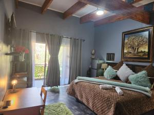 a bedroom with a bed and a table and a window at Suikerbosrant Sleep and go in Pretoria +219 photos