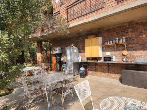 a patio with a table and chairs and a kitchen at Suikerbosrant Sleep and go in Pretoria