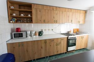 a kitchen with wooden cabinets and a stove and microwave at Casa Liana in Buşteni