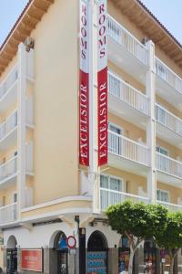 un edificio con pancartas rojas y blancas. en Excelsior Estudios & Apartamentos, en San Antonio