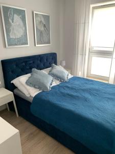 a blue bed with two pillows on it in a bedroom at Apartament Kalina in Lublin