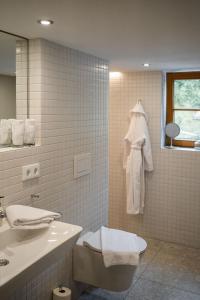 W łazience znajduje się umywalka, toaleta i lustro. w obiekcie Ferienwerk w mieście Ofterschwang
