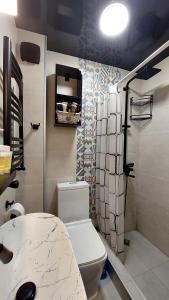 een badkamer met een wit toilet en een douche bij Apartment Rustaveli 118 in Koetaisi