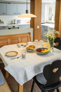 オフターシュヴァングにあるFerienwerkの白いテーブルクロスと食べ物を載せたテーブル