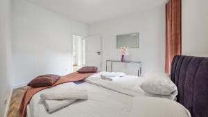 赫爾的住宿－Apartamenty Sun & Snow Belnihel，一间卧室配有带毛巾的床