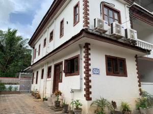 ein weißes Gebäude mit Fenstern und einem Balkon in der Unterkunft 3 Bedroom villa with Private Pool in North Goa in Assagao