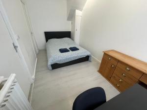 ein kleines Schlafzimmer mit einem Bett und einem Schreibtisch in der Unterkunft Appartement à 200 mètres de la gare in Rouen